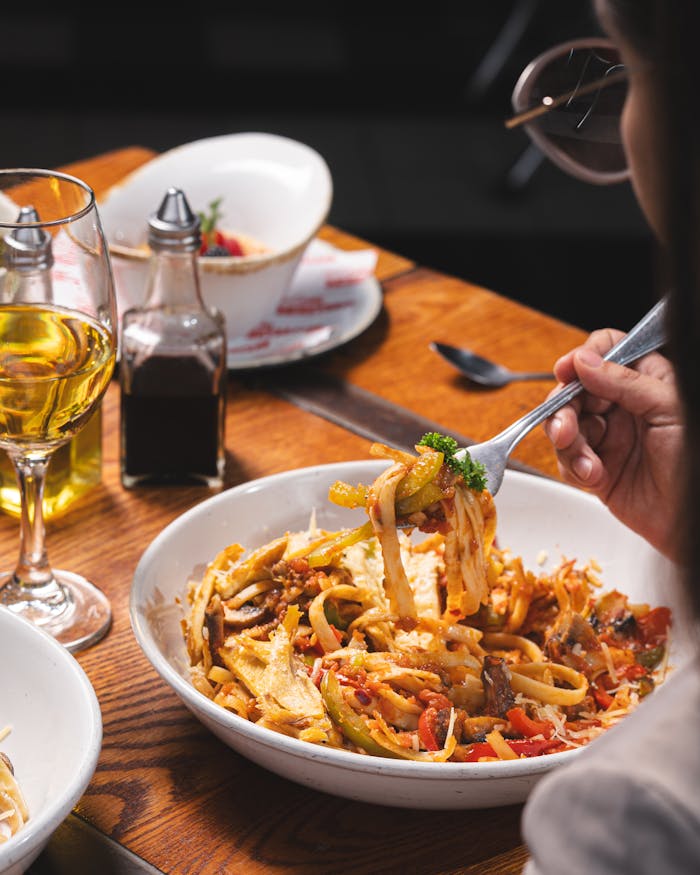 A close-up of a delicious Italian pasta dish with wine, perfect for a gourmet meal.